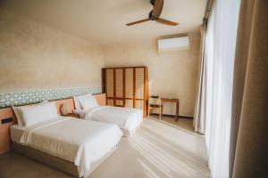 ein Schlafzimmer mit zwei Betten und einem Deckenventilator in der Unterkunft Cactus Village Penida in Nusa Penida + 38 Fotos