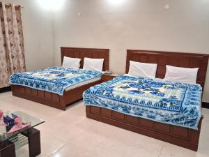 カラチにあるFamily Rose Guest House Millenniumの- ベッド2台(青と白のシーツ付)