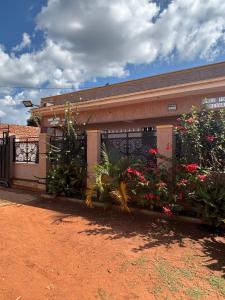 a building with a bunch of flowers in front of it at Freetown resort-Gulu in Gulu