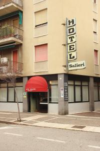 un edificio con un toldo rojo y un cartel en Hotel Salieri, en Legnago