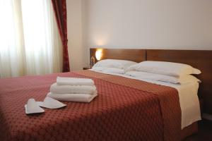 Una cama con toallas y zapatos encima. en Hotel Salieri, en Legnago 10 fotos más