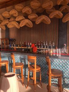 eine Bar mit Holzstühlen und einem Tresen mit vielen Kronleuchtern in der Unterkunft Cactus Village Penida in Nusa Penida