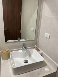 a white sink in a bathroom with a mirror at Ocean Garden Villas Cluster B 3rd Floor Unit C in Boracay +10 photos