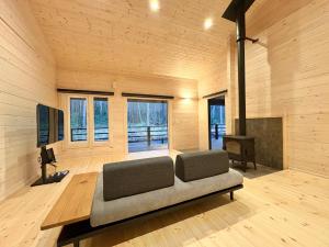 a living room with a couch and a television at Second House LUONTO in Tsumagoi