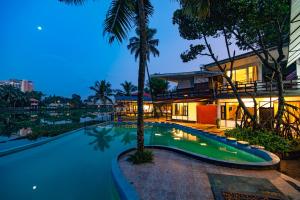 Una imagen de la piscina de un complejo turístico por la noche. en Mia Riaan Lake View Resort, en Ernakulam