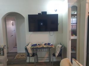 a living room with a table and a flat screen tv on the wall at Haven of Rest Suite in Nevis