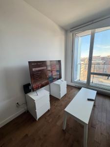 een witte kamer met een tafel en een groot raam bij Cosy old port in Montreal +5 foto's