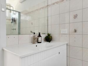 Un baño blanco con lavabo y espejo. en Sunlit Waters at Batemans, en Nelligen 26 fotos más