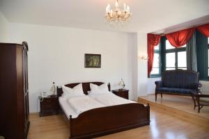 a bedroom with a bed and a blue chair at Altstadthotel Garni Schlundhaus & Rautenkranz in Meiningen