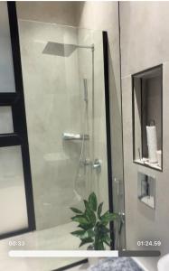una doccia con una porta in vetro in un bagno di شاليه وجد a Shaqra