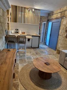 a living room with a table and a kitchen at 'I Elea' Village House with Courtyard in Letimbou