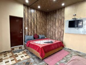a bedroom with a bed with a tv on the wall at Hotel Sunrise Inn & Restaurant, Kanatal in Chamba