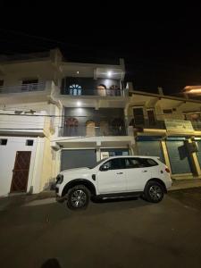 a white car parked in front of a building at shivoham Stays in Mājra