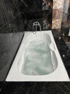 a bath tub filled with water with a faucet at shivoham Stays in Mājra