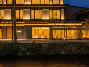 a building with lit up windows at night at AKEKURE Kyoto Shirakawa in Kyoto +86 photos