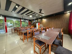a dining room with wooden tables and chairs at Hotel Sunrise Inn & Restaurant, Kanatal in Chamba