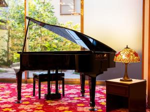 a piano on display in a room with a lamp at BeppuOnsen Hotel Sansenkaku in Beppu