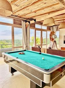 einen Billardtisch in einem Zimmer mit Fenstern in der Unterkunft The Castle Uluwatu - Ocean View Luxury villa in Uluwatu