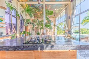 eine Insel in einem Raum mit Fenstern und Pflanzen in der Unterkunft The Castle Uluwatu - Ocean View Luxury villa in Uluwatu