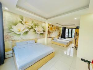 een slaapkamer met 2 bedden en een schilderij van bloemen bij The 1996 House in Lao Cai