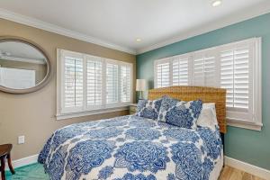Schlafzimmer mit einem Bett, einem Spiegel und Fenstern in der Unterkunft Bungalow Beach Place 9 in Clearwater Beach