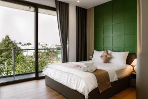 um quarto com uma cama e uma janela grande em Petit Hotel em Thu Dau Mot