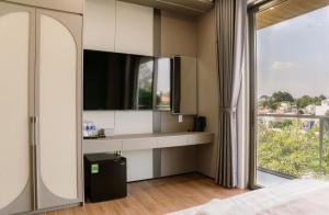 een slaapkamer met een bed en een groot raam bij Petit Hotel in Thu Dau Mot