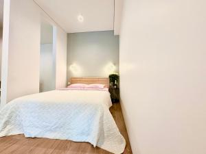 a bedroom with a white bed and a wall at Lux Garden Appartments in Kharkiv
