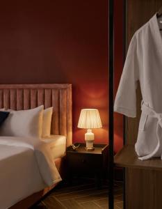 um quarto com uma cama e um abajur sobre uma mesa em Lovera Hotel Airport em Cidade de Ho Chi Minh