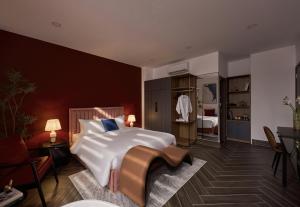 a bedroom with a large white bed and a chair at Lovera Hotel Airport in Ho Chi Minh City