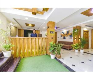 印多尔HOTEL SiGNOR的一个男人站在摆满植物的大厅柜台前。