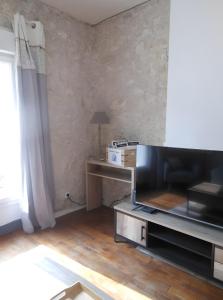 Una sala de estar con un televisor de pantalla plana grande. en Gîte Le Rabelais, en Thésée