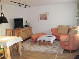 een woonkamer met een bank en een tv bij Urlaub bei Alma in Wurster Nordseeküste