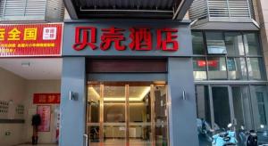 ein Gebäude mit einem Schild an der Vorderseite in der Unterkunft Shell Hotel Hefei Feixi County Huamucheng in Shangpai