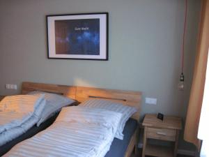twee bedden in een slaapkamer met een foto aan de muur bij Urlaub bei Alma in Wurster Nordseeküste