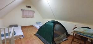 um quarto com uma tenda e duas camas dentro. em Cimanggu forest guest house em Baruhtunggul