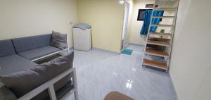 uma sala de estar com um sofá e uma geladeira em Cimanggu forest guest house em Baruhtunggul