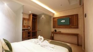 a bedroom with a bed with a tv on the wall at Uma Tilu By Seken Living in Yogyakarta