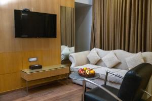 a living room with a couch and a bowl of fruit at Ramee Guestline Hotel Dadar in Mumbai