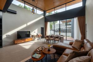 een woonkamer met een bank en een tv bij Balance Village in Ko Phangan