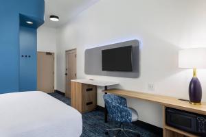ein Hotelzimmer mit einem Bett und einem Schreibtisch mit einem TV in der Unterkunft Sleep Inn & Suites Round Rock - Austin North in Round Rock