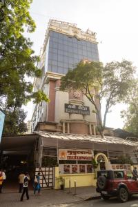 a building with a sign in front of a store at Ramee Guestline Hotel Dadar in Mumbai
