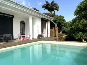 a swimming pool in front of a house at Kaz coco mango in Basse-Terre
