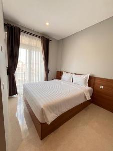 een slaapkamer met een groot bed en een groot raam bij Aluna Bay Hotel in Balige +14 foto's