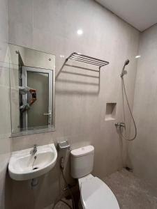een badkamer met toilet en wastafel bij Aluna Bay Hotel in Balige