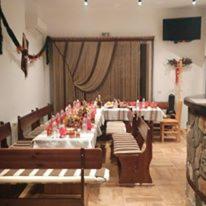 a large room with a table with chairs and a cross at Rodopsko Katche in Alamovtsi