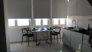 a kitchen with a table and chairs in a kitchen at SeaShell Apartment - Sesimbra in Sesimbra