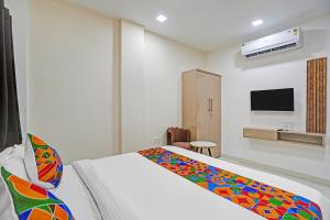 Un dormitorio con una cama con una manta colorida encima. en FabHotel Amrit Palace, en Indore 19 fotos más