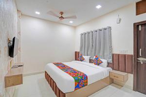 un dormitorio con una cama en una habitación en FabHotel Amrit Palace, en Indore