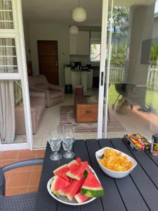 een tafel met twee borden fruit en wijnglazen bij The Flip Flop Stop in Ballito